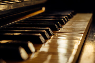 Close-up of black and white keys of an old wooden piano. Vintage piano keyboard, selective focus,...