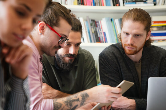 Team of multiethnic diverse young software developers talk, discuss an AI project. Business startup