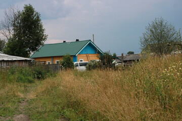 a yellow house on a background of blue sky and green grass