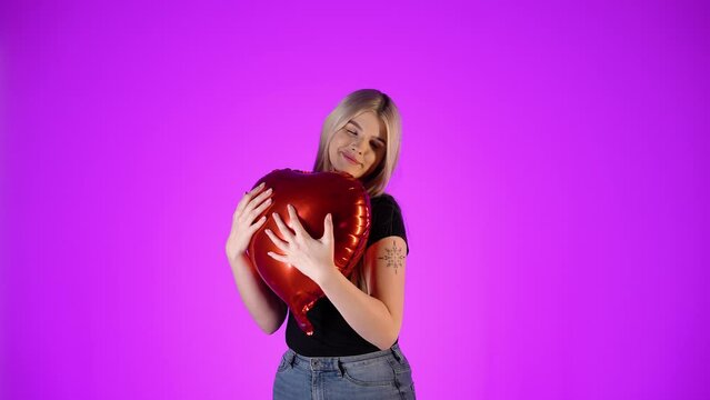 Kobieta przytula czerwony balon w kształcie serca