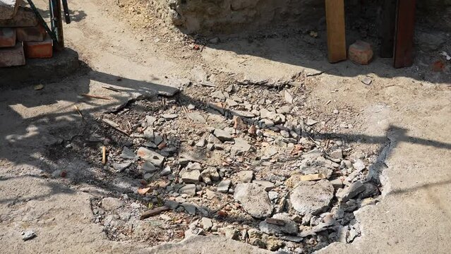 Crater after artillery shelling. Russian-Ukrainian War. Destroyed house after artillery shelling