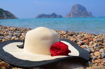 Ibiza, Es Vedra island in the fog. View of a mysterious island in the sea. Woman's hat with rose...