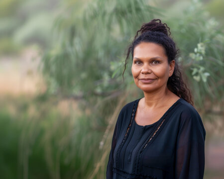 A woman in black standing outdoors.