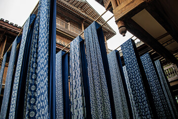 China. Blue and white indigo print chintz - traditional cotton fabric, indigo rags hung to dry,...