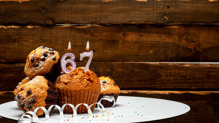 Pies with a number 67  of candles burning for the anniversary. Copy space background happy birthday...