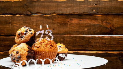 Pies with a number 73  of candles burning for the anniversary. Copy space background happy birthday...