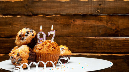 Pies with a number 97  of candles burning for the anniversary. Copy space background happy birthday on wooden background. Card or postcard festive rustic brown. - obrazy, fototapety, plakaty