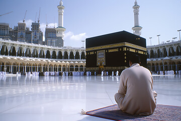 Muslim Man with his hands up infront kaaba at the mosque