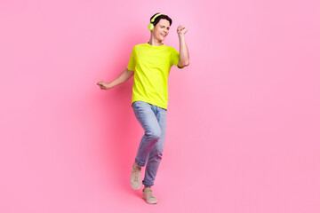 Full length photo of funky cool man dressed yellow t-shirt headphones dancing enjoying music isolated pink color background