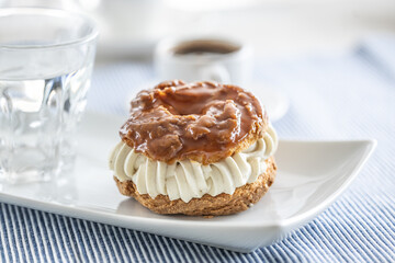 Veternik - sweet donut, typically Slovak caramel sweet cake with cream filling topped with caramel on a plate in a cafe