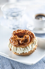 Veternik - sweet donut, typically Slovak caramel sweet cake with cream filling topped with caramel on a plate in a cafe
