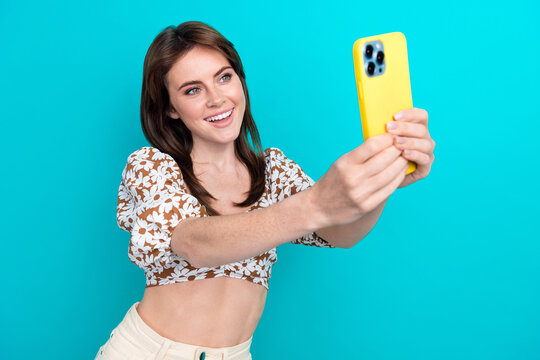 Photo of young charming lady get new apple iphone 15 recording video selfie herself in social media isolated on cyan color background