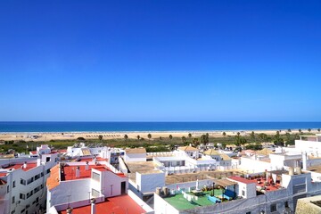 view from the Torre de Guzman tower over the roofs of Conil de la Frontera towards the dunes and...