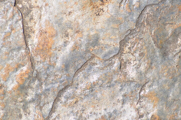 Stone surface texture with gray and beige colors, irregular and rough surface
