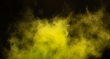 Yellow powder dust smoke on black background