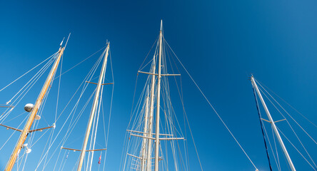 several masts of a yacht without sails