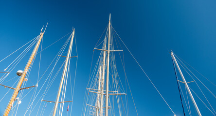 several masts of a yacht without sails