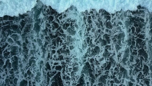 Aerial view over the mesmerizing dark waves of the ocean.