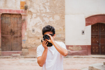 young latin man traveler photographer taking pictures in an ancient city