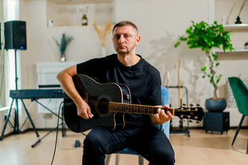 Obraz premium brutal sad rock artist with electric guitar in recording studio playing musical instrument during rehearsal