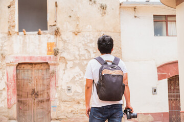 Fototapeta na wymiar young latin male traveler photographer exploring ancient city and taking pictures with camera