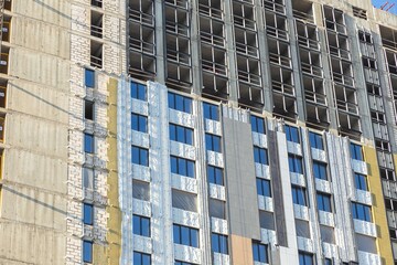 Modern Building Under Construction with Insulation Layers Exposed Facade Works