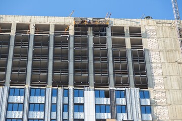 Modern Building Under Construction with Insulation Layers Exposed Facade Works