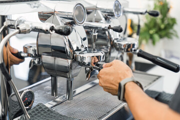 Espresso machine making hot coffee on counter in coffee shop