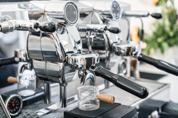 Espresso machine making hot coffee into dosing cup in coffee shop