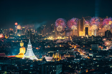 Bangkok night scene with big buddha in temple and firework display show over department store in crowded downtown