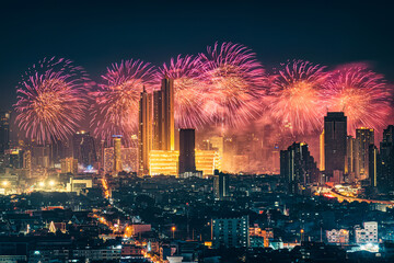 New year festival with firework display glowing over department store, illuminated building in downtown during midnight time at Bangkok, Thailand