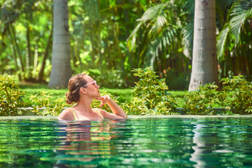 attractive woman relaxing on a spa's swimming pool.