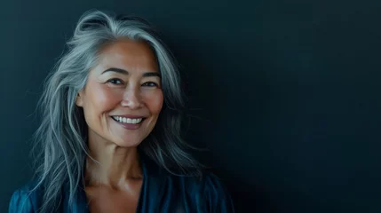 Foto op Canvas Happy smiling stylish confident 50 years old Asian female professional standing looking at camera at gray background. Portrait of sophisticated grey hair woman advertising products. © Nataliia_Trushchenko