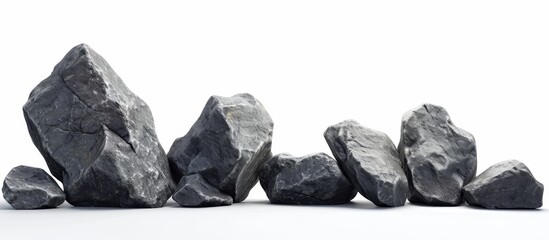 A still life photograph showcasing a monochrome landscape of black rocks on a white background, resembling bedrock, a natural material, with a touch of metal.