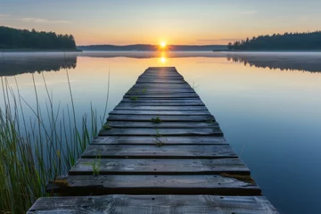 Muurstickers Weathered wooden dock, extending into a serene lake at sunrise. © furyon