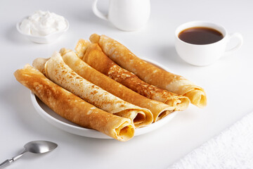 Stack of russian thin pancakes blini with fresh sour cream