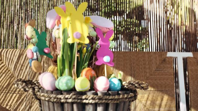 Excited emotion child girl in rabbit costume ears hide  spring Easter composition with yellow flowers, paper colored Easter bunny, eggs wood basket