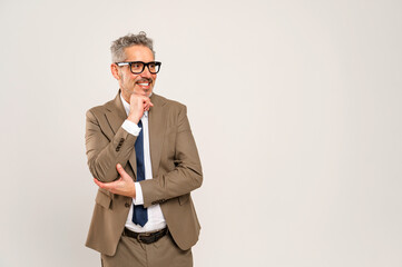 Captured in mid-thought, the mature businessman touches his chin, his eyes expressing consideration...