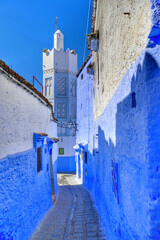 Traditional mosque and houses along alleyway in Chefchaouen, Morocco