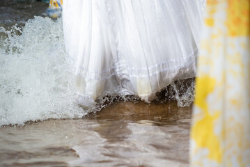 Lower part of unidentified people entering the water of the mara to pay homage to Iemanja.