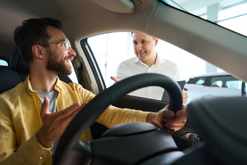 Buyer in a car is studying functionality of popular model