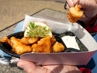 Fried codfish nuggets with lemon and mayonnaise in a cardboard tray, Netherlands
