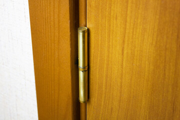 Metal hinge on a wooden entrance door, interior door hinge.