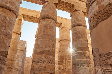 Different hieroglyphs on the walls and columns in the Karnak temple. Columns and blue sky in the great hypostyle hall at the karnak temple, Egypt