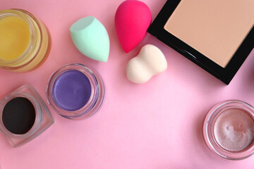 Various colorful beauty products on bright pink background. Top view.