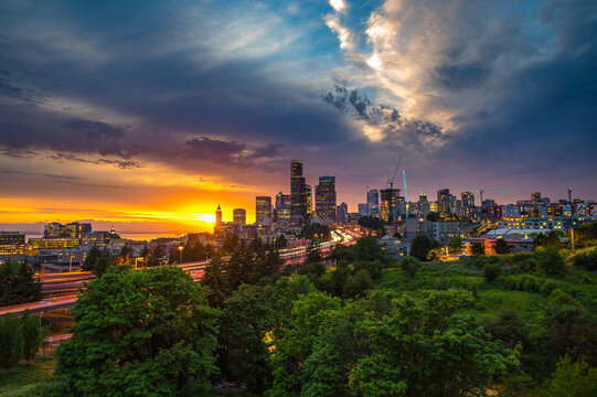 Dramatic sunset over the Seattle skyline, with traffic on the I-5 and I-90 freeway interchange, viewed from Dr. Jose Rizal Bridge.