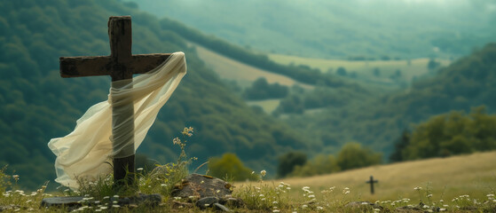 Sheer white scarf wrapped around wooden cross grave marker sitting on the edge of a precipice overlooking a verdant valley dotted with hay meadows and encircled by forested slopes.  - obrazy, fototapety, plakaty