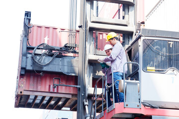 Engineer wearing safety helmet working in container warehouse industry.