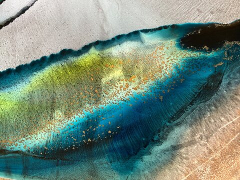 Abstract fluid art in green and turquoise tones. Hand-made with alcohol ink. Features organic flowing shapes. No real property or natural materials depicted.
