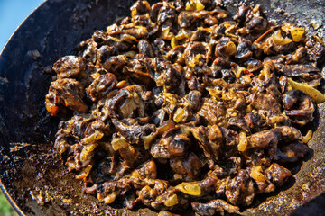 Hiker's food. Grape snails fried in a frying pan with vegetables